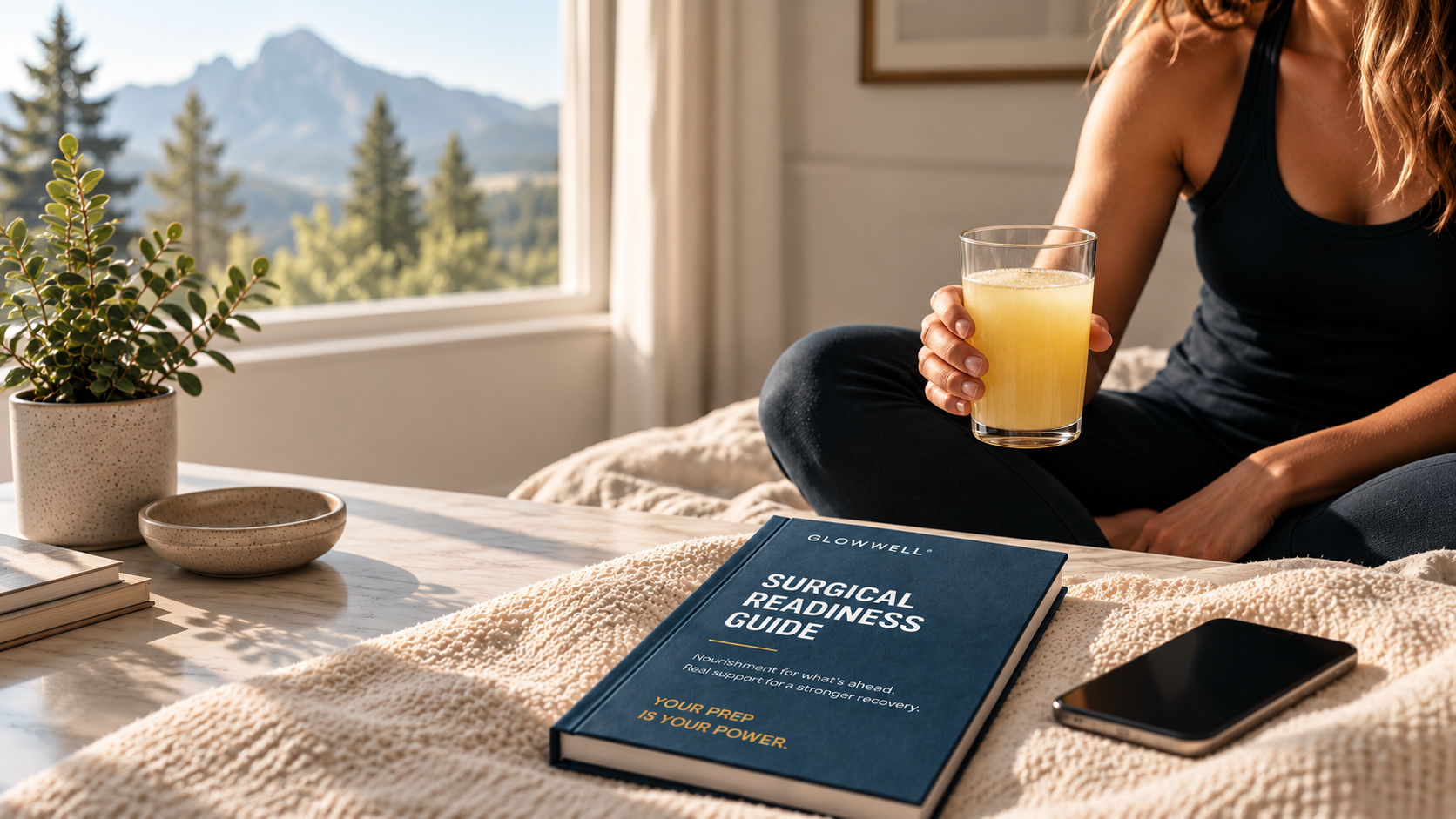 A woman sitting in morning light holding a glass of PREP beside the Surgical Readiness Guide